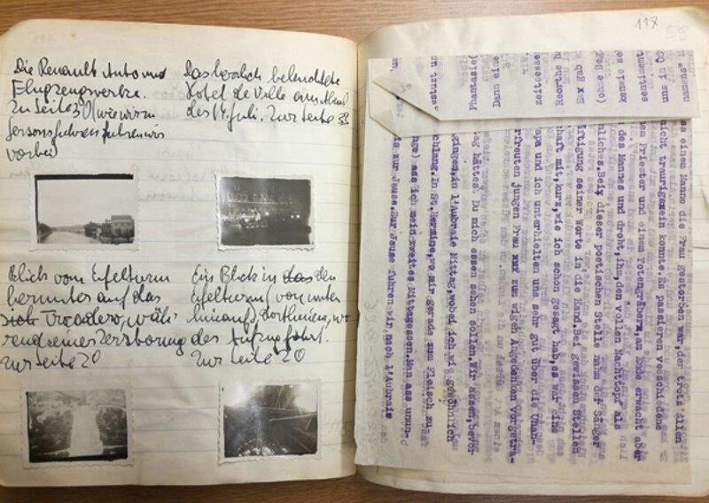 Notizbuch mit eingeklebten Fotos und einem eingelegten Zettel, blau beschrieben