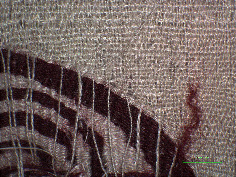Textil aus der Nähe, rote Spirale auf Weiß