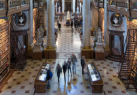 Barocker Bibliothekssaal mit Menschen von oben fotografiert