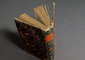 Altes Buch, offen auf Tisch stehend, von hinten