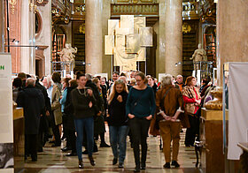 Gut besuchter Prunksaal mit goldenem Porträt von Ludwig van Beethoven im Hintergrund.