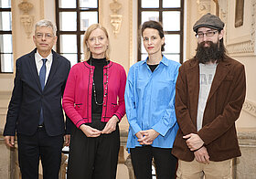 Vier Personen posieren für Foto.