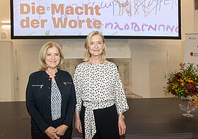 Zwei Personen posieren vor Bühne.