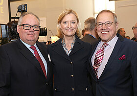 Drei Personen posieren auf Veranstaltung.