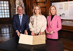Drei Personen posieren für ein Foto. 