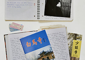 Foto von verschiedenen offenen, beschriebenen Notizbüchern, Fotos und Andenken.