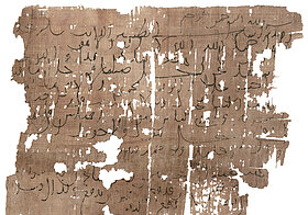 Lose beschrifteter Papyrus.