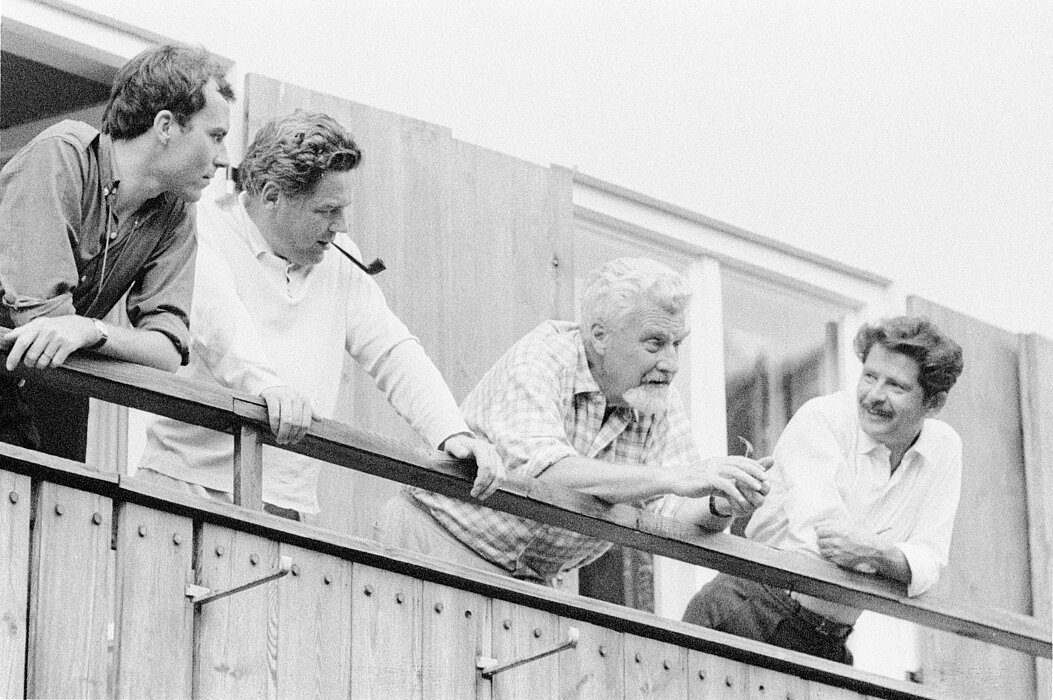 Schwarz-Weiß-Foto vier Menschen, die auf einem Balkon stehen.
