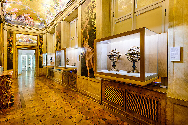 Foto von goldverziertem Raum mit Globus-artigen Geräten hinter Glas