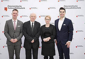 Vier Menschen posieren für ein Foto.