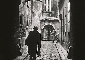 Foto von Person, der durch Tunnel geht, gegen das Licht fotografiert.