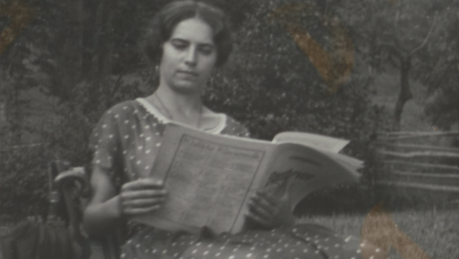 Schwarz-weißes Foto von Person, die im Garten sitzt und liest.