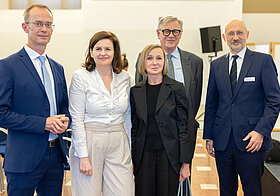 Fünf Personen posieren auf Event.
