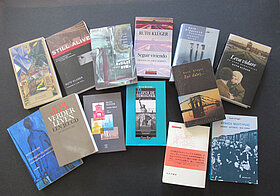 Viele bunte Bücher auf einem schwarzen Tisch