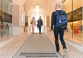 Eingang des Literaturmuseums. Personen verlassen und betreten das Museum