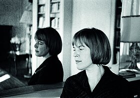 Ingeborg Bachmann vor einem Spiegel, im Profil. Ihr Gesicht ist zwei Mal zu sehen. 