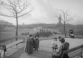 Personen und Kinder in einer kargen Parklandschaft.