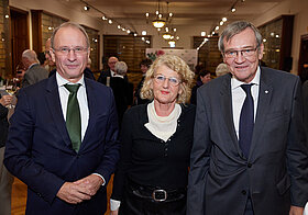 Drei Personen posieren auf Event.