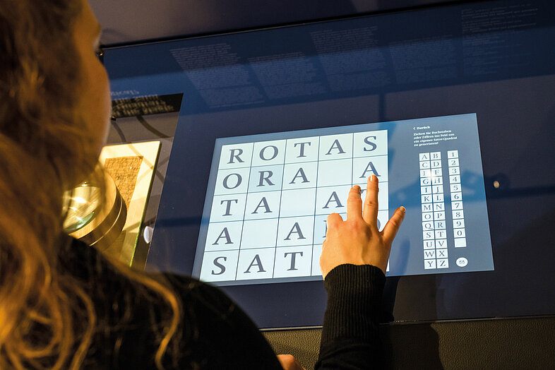 Foto von Person, die Touchscreen in Museum berührt.