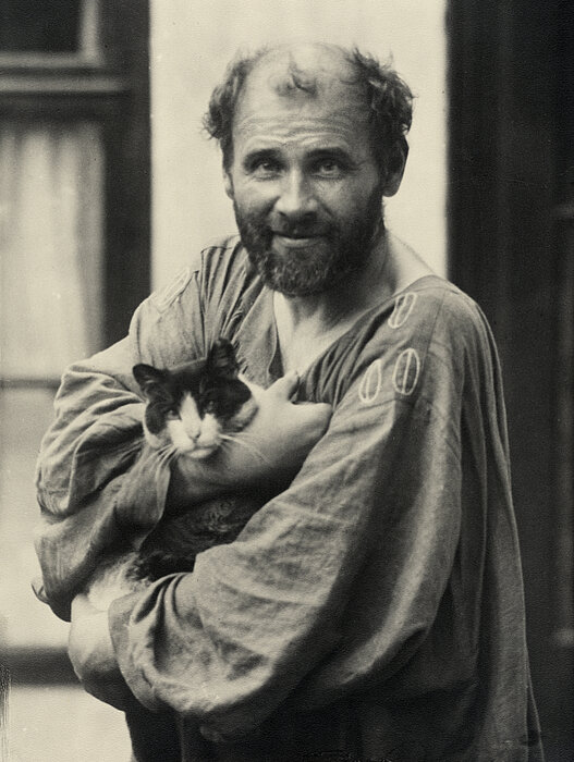 Schwarz-weißes von Person, die eine Katze im Arm hält.