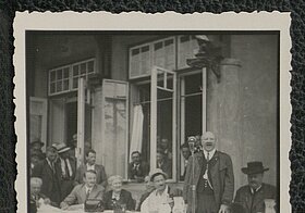 Schwarz-weißes Foto von Personen an einem Tisch sitzend.