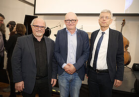 Drei Personen posieren für ein Foto. 