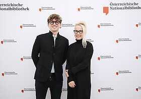 Zwei Menschen posieren für ein Foto.