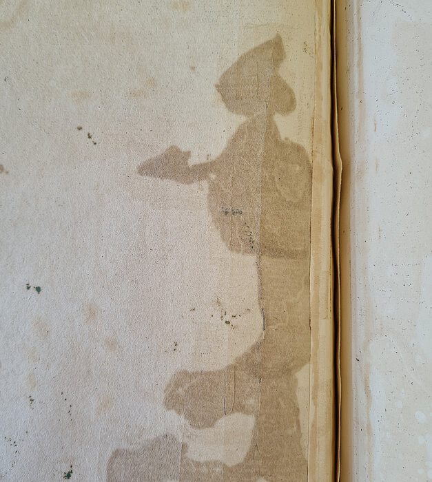 Fleck auf Papier, Riss mit anderem Papier repariert. 