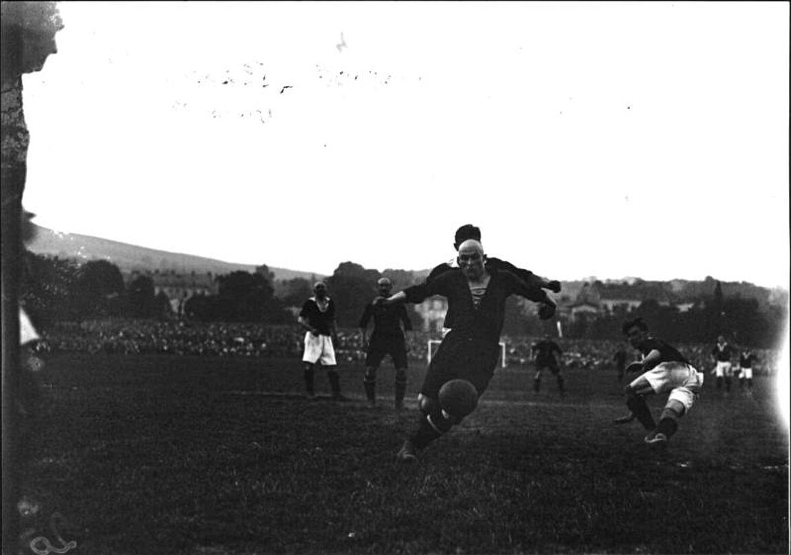 Schwarz-weißes Foto von Fußballspielern am Feld.