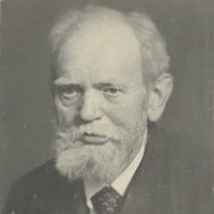 Schwarz-weißes Porträtfoto von einem ernsten Mann mit weißem Bart und Anzug
