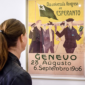 BesucherIn im Esperantomuseum vor einem Poster für eine Veranstaltung in Esperanto