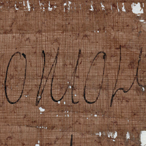 Detailaufnahme von Schrift auf löchrigem Papyrus